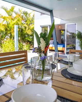 a wooden table with a vase with flowers in it at Villa Dos Vistas in Uvita