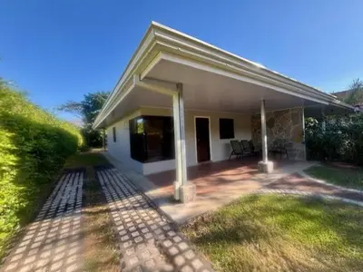 a small white house with a patio in the yard at Los Delfines 560 in Tambor