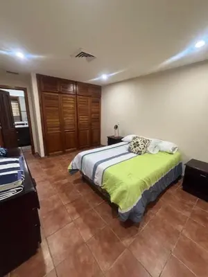 a bedroom with a bed with a green blanket at Los Delfines 560 in Tambor