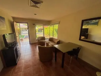 a living room with a table and chairs and a television at Los Delfines 560 in Tambor