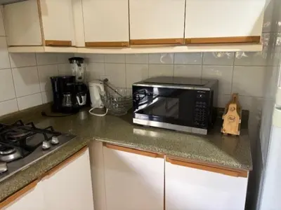 a kitchen counter with a microwave and a stove at Los Delfines 560 in Tambor