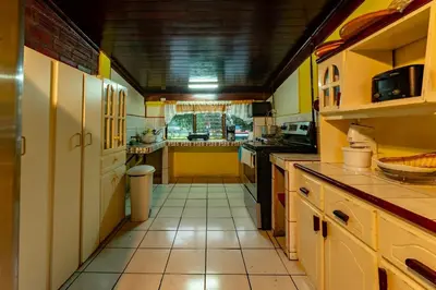 a large kitchen with yellow walls and white cabinets at Casa Rector - Beach House Rental in El Roble