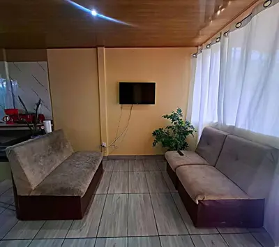 a living room with a couch and a tv at Casa Jako's in Uvita