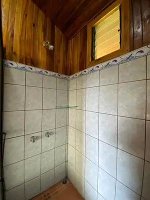 a bathroom with a tiled shower with a window at Makena Rancho in Monteverde Costa Rica