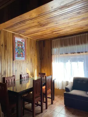a dining room with a table and chairs and a couch at Makena Rancho in Monteverde Costa Rica
