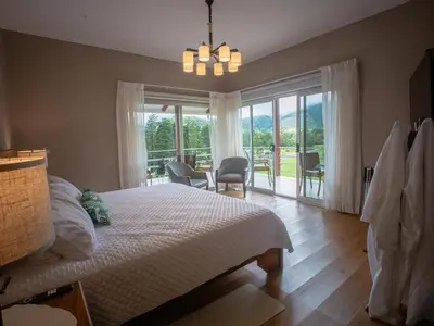 a bedroom with a bed and a balcony with a view at Casa las Luciernagas in Bajos del Toro
