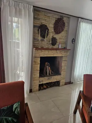 a living room with a stone fireplace in a house at Casa las Luciernagas in Bajos del Toro