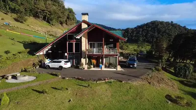 a house on a hill with cars parked in front at Casa las Luciernagas in Bajos del Toro