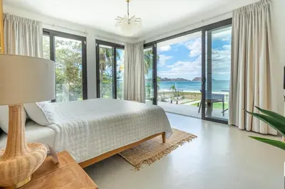 a bedroom with a bed and a view of the ocean at CASA AZUL - Luxury Beachfront Mansion in Potrero