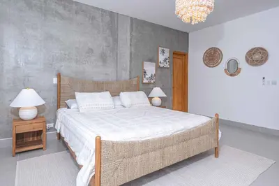 a bedroom with a bed and two lamps and a chandelier at CASA AZUL - Luxury Beachfront Mansion in Potrero