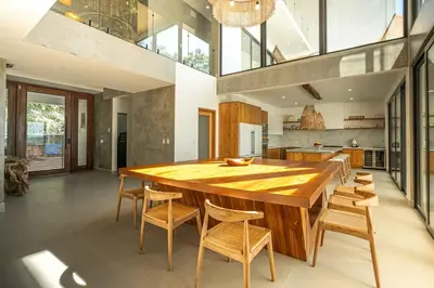 a large dining room with a wooden table and chairs at CASA AZUL - Luxury Beachfront Mansion in Potrero