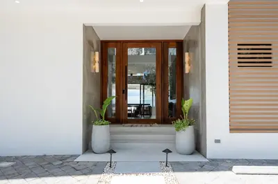 a front door of a house with two potted plants at CASA AZUL - Luxury Beachfront Mansion in Potrero