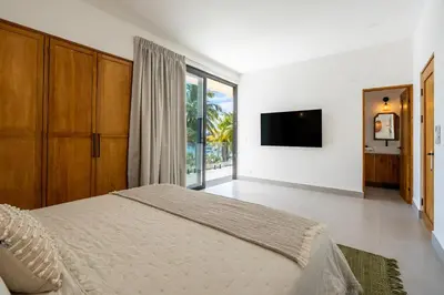 a bedroom with a bed and a flat screen tv at CASA AZUL - Luxury Beachfront Mansion in Potrero