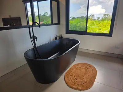 a black bath tub in a bathroom with windows at Casa Brisa Moderna, para 8 personas in Jabillos