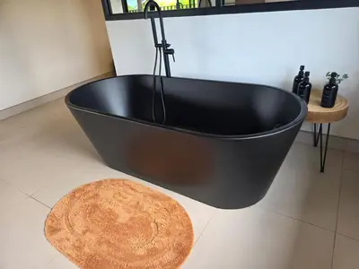 a black bath tub in a bathroom with a rug at Casa Brisa Moderna, para 8 personas in Jabillos