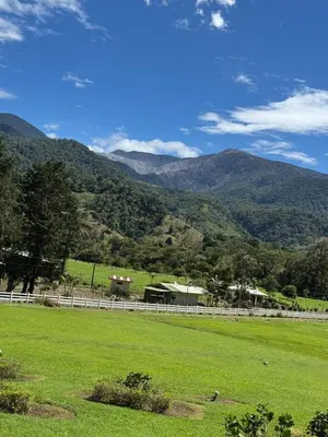 a field with a fence and mountains in the background at Casa Hortensias in Bajos del Toro