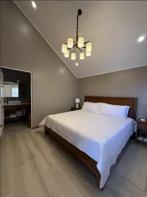 a bedroom with a white bed and a chandelier at Casa Hortensias in Bajos del Toro