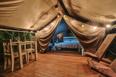 a bedroom with a bed in a tent with lights at Flor y Bambu in Playa Grande