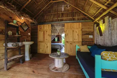 a room with a couch and a table in a cabin at Flor y Bambu in Playa Grande