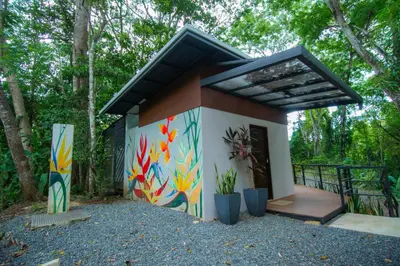 a small house with a painting on the side of it at Selva Color - Forest & Beach EcoLodge in Quebrada Ganado