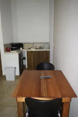 a wooden table with two chairs in a kitchen at Villas Maria Luisa in Uvita