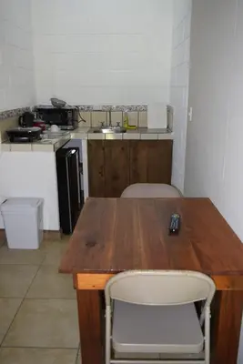 a kitchen with a wooden table and two chairs at Villas Maria Luisa in Uvita