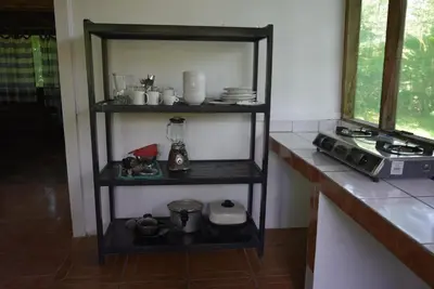a kitchen with a shelf with dishes and a blender at Villas Maria Luisa in Uvita