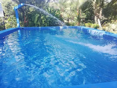 a large swimming pool with a water fountain at Villas Maria Luisa in Uvita