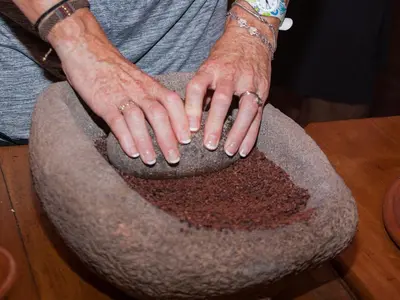 a person with their hands on a bowl of dirt at Finca Luna Nueva Lodge in Fortuna