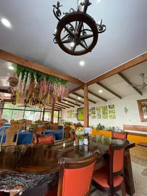 a dining room with a table and a chandelier at Hotel y Puentes Colgantes Heliconias Rainforest Lodge in Bijagua