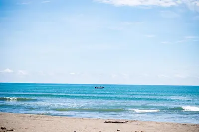 a boat in the water on the beach at Hotel Tortuguero Beachfront in Tortuguero
