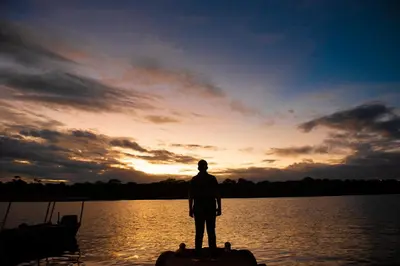 a man standing on a dock in front of a body of water at Hotel Tortuguero Beachfront in Tortuguero