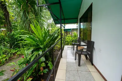 a balcony of a house with a table and chairs at Hotel Tortuguero Beachfront in Tortuguero