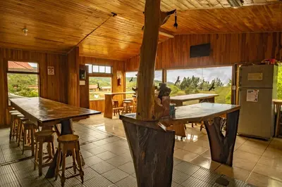 a room with tables and chairs and a refrigerator at Hostel La Suerte in Monteverde Costa Rica