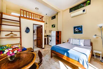 a bedroom with a bed and a table and a kitchen at Villa Nautilus in Tamarindo