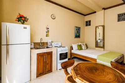 a kitchen with a refrigerator and a table in a room at Villa Nautilus in Tamarindo