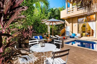 a patio with a table and chairs next to a pool at Villa Nautilus in Tamarindo