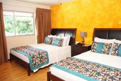 a hotel room with two beds and a window at Hotel Vista De Golf, San Jose Aeropuerto, Costa Rica in San José