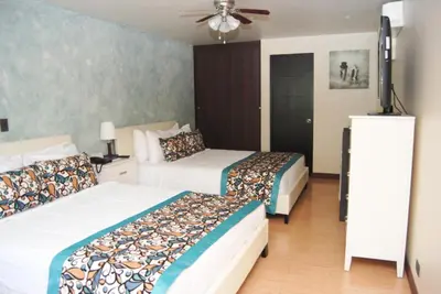 a hotel room with two beds and a fan at Hotel Vista De Golf, San Jose Aeropuerto, Costa Rica in San José