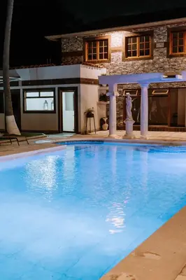 a large swimming pool in front of a house at Hotel Vista De Golf, San Jose Aeropuerto, Costa Rica in San José