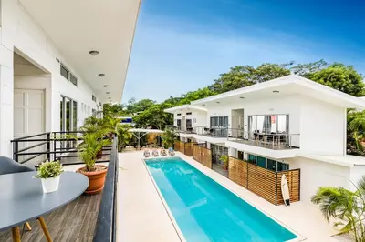an open balcony with a swimming pool and a house at In the Shade Hotel - Coworking - 300Mbit - Adults Only in Tamarindo