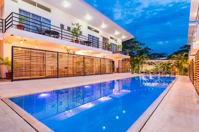 a swimming pool in front of a house at In the Shade Hotel - Coworking - 300Mbit - Adults Only in Tamarindo