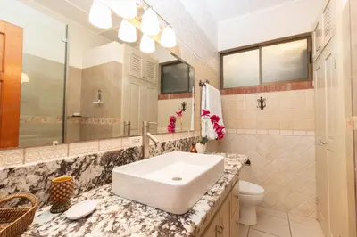 a bathroom with a sink and a toilet and a mirror at Stunning Villa with Oceanview, Private Pool, Soaking Tub & Picturesque Balcony in Playa Flamingo
