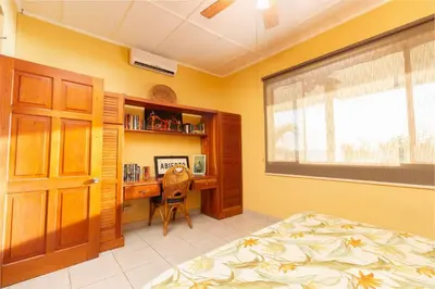a bedroom with a bed and a desk and a window at Stunning Villa with Oceanview, Private Pool, Soaking Tub & Picturesque Balcony in Playa Flamingo