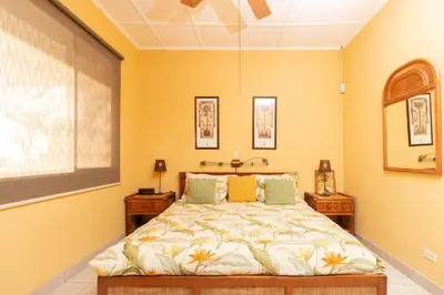 a bedroom with a bed and two night stands at Stunning Villa with Oceanview, Private Pool, Soaking Tub & Picturesque Balcony in Playa Flamingo