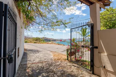 a gate to a house with a view of the water at Stunning Villa with Oceanview, Private Pool, Soaking Tub & Picturesque Balcony in Playa Flamingo