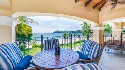 a balcony with a table and chairs and a view of the ocean at Stunning Luxury Mansion in Playa Flamingo with Six Bedrooms and Beachfront Access in Playa Flamingo