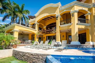a villa with a swimming pool and a resort at Elegant Mediterranean-Style Mansion with Beachfront Views and Private Infinity Pool in Playa Flamingo