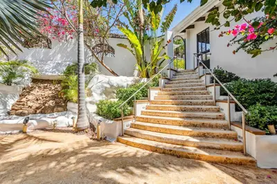 a set of stairs in front of a house at Dreamy Spanish-Style Villa with Sweeping Ocean Views, Elegant Nautical Design & Giant Infinity Pool in Playa Flamingo