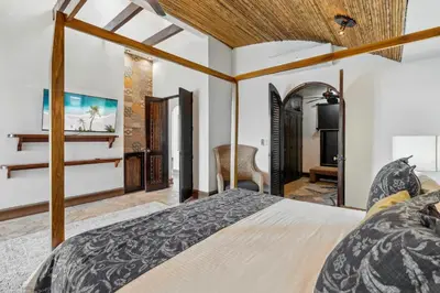 a bedroom with a large bed and a desk at Dreamy Spanish-Style Villa with Sweeping Ocean Views, Elegant Nautical Design & Giant Infinity Pool in Playa Flamingo
